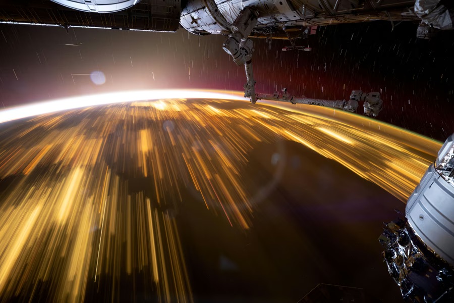 Earth at night from the International Space Station, showing city lights as golden streaks